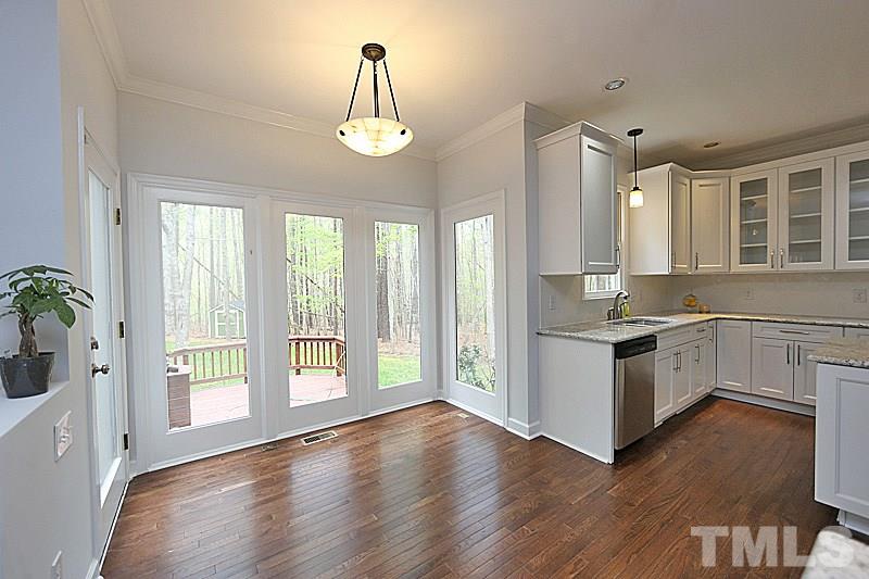 12317 Glenlivet Way Raleigh, NC 27613 - Photo 7 of 25 a kitchen with stainless steel appliances granite countertop a stove a sink and a large window