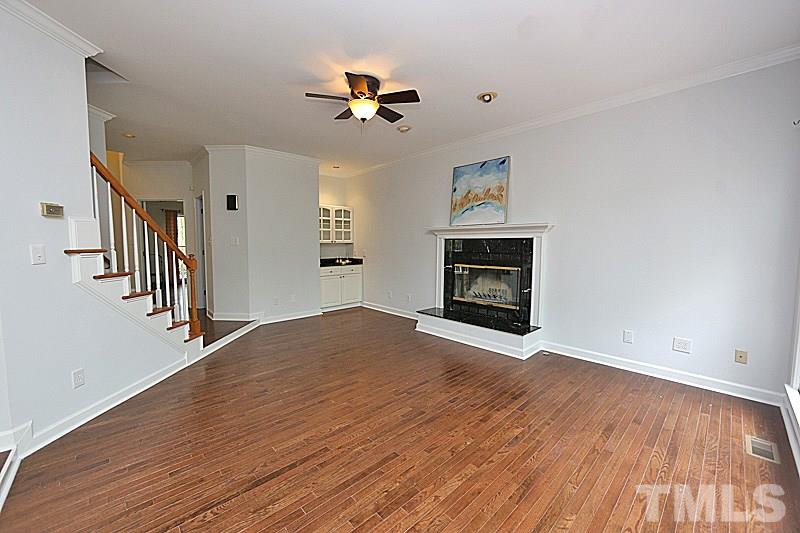 12317 Glenlivet Way Raleigh, NC 27613 - Photo 9 of 25 a view of empty room with wooden floor and fireplace