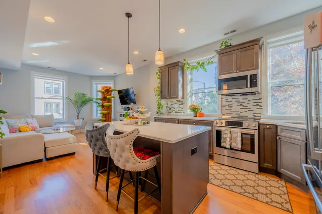 a kitchen with a sink stove and wooden floor