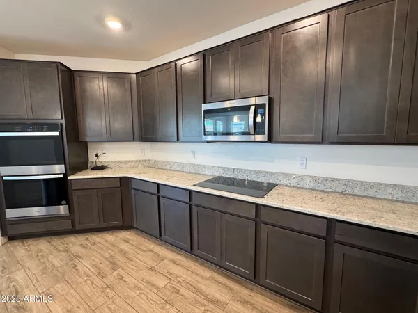 a kitchen with stainless steel appliances granite countertop a refrigerator and a stove top oven