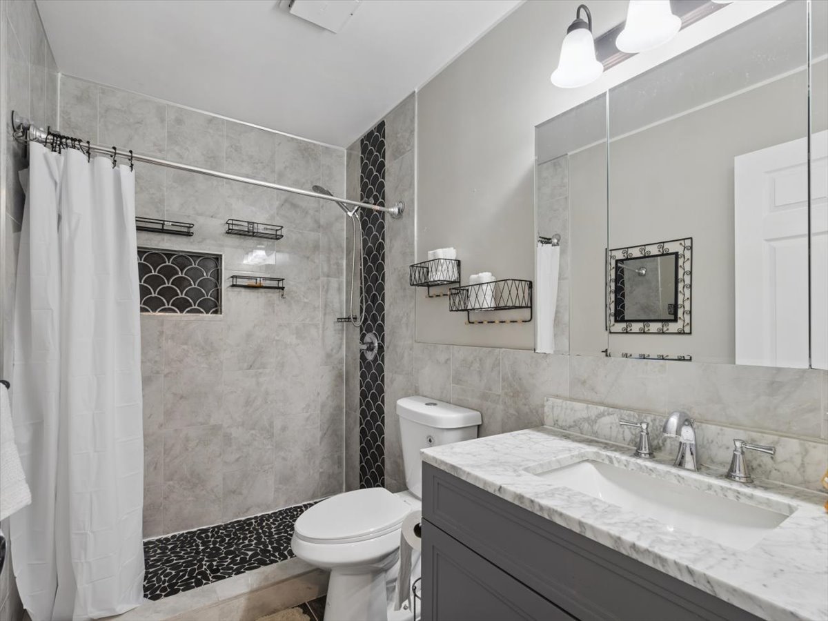 1220 Fulton Drive Streamwood, IL 60107 - Photo 11 of 18 a bathroom with a granite countertop sink toilet and shower