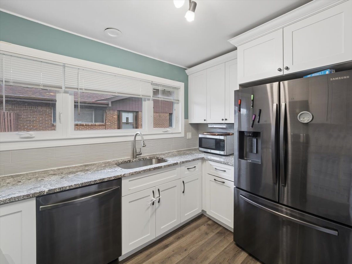 1220 Fulton Drive Streamwood, IL 60107 - Photo 8 of 18 a kitchen with granite countertop stainless steel appliances a refrigerator a sink and cabinets