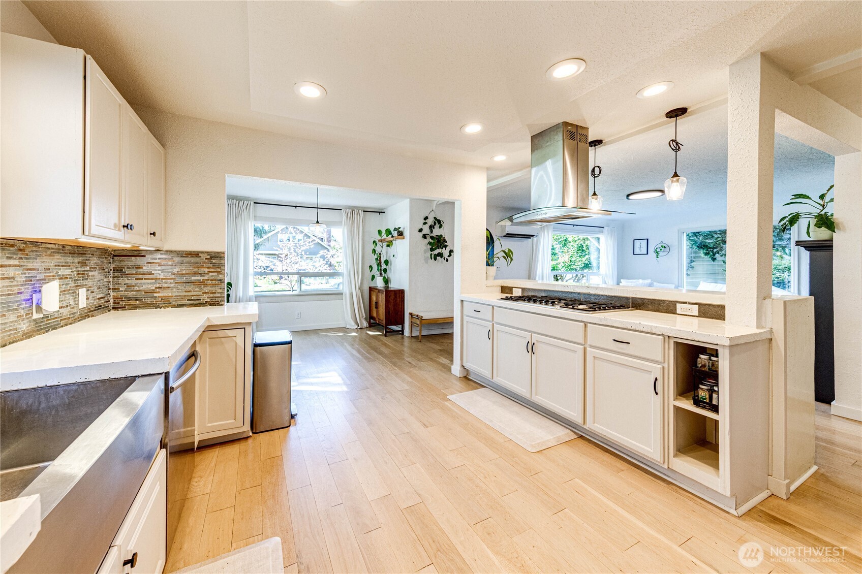 231 West 4th Street Port Angeles, WA 98362 - Photo 15 of 40 a kitchen with stainless steel appliances white cabinets and wooden floors