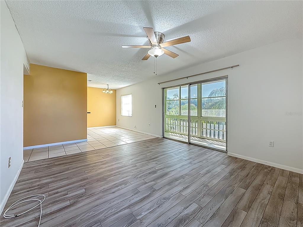 379 South McMullen Booth Road, Unit 76 Clearwater, FL 33759 - Photo 11 of 39 a view of an empty room with wooden floor and a window