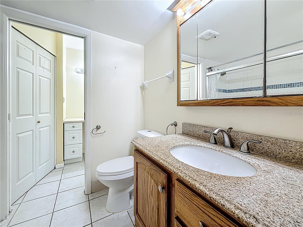 379 South McMullen Booth Road, Unit 76 Clearwater, FL 33759 - Photo 20 of 39 a bathroom with a granite countertop sink mirror vanity and toilet