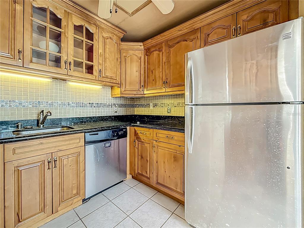379 South McMullen Booth Road, Unit 76 Clearwater, FL 33759 - Photo 5 of 39 a kitchen with stainless steel appliances granite countertop a refrigerator a sink and white cabinets