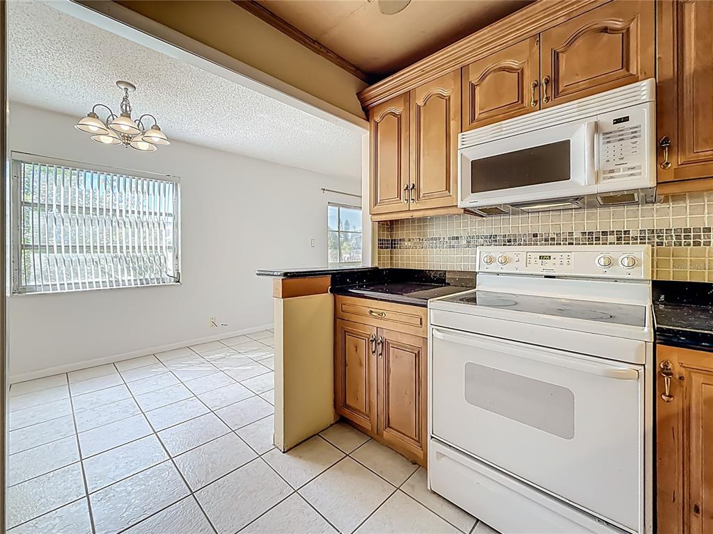 379 South McMullen Booth Road, Unit 76 Clearwater, FL 33759 - Photo 7 of 39 a kitchen with granite countertop cabinets stainless steel appliances and a sink