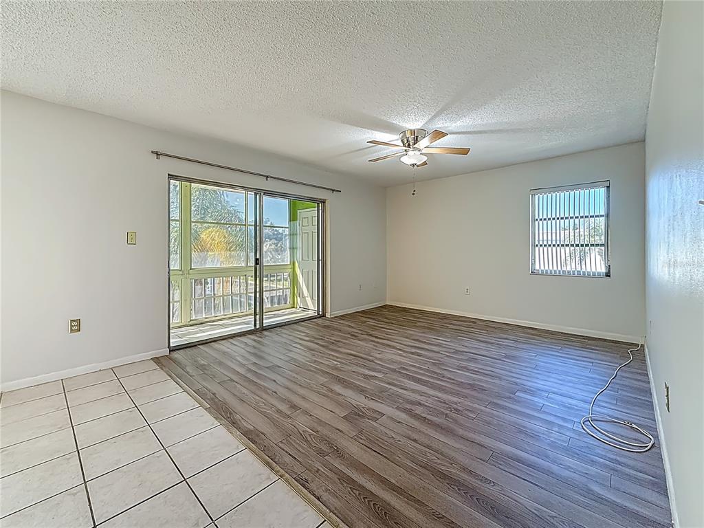 379 South McMullen Booth Road, Unit 76 Clearwater, FL 33759 - Photo 9 of 39 a view of an empty room with a window and wooden floor
