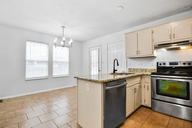 a kitchen with stainless steel appliances granite countertop a sink stove and cabinets