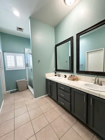 a bathroom with a double vanity sink mirror and bathtub