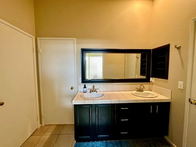 a bathroom with a double vanity sink and a mirror