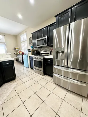 a kitchen with stainless steel appliances granite countertop a refrigerator sink and stove