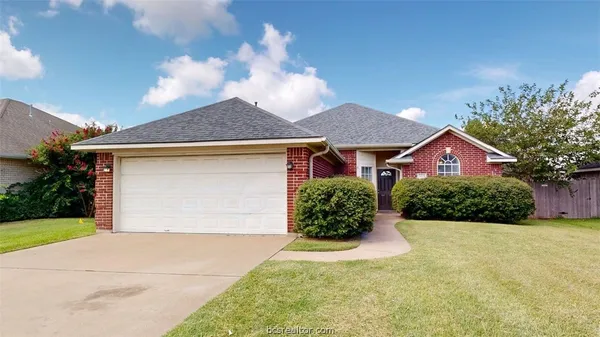 a front view of house with yard and garage