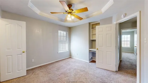 an empty room with closet and a ceiling fan