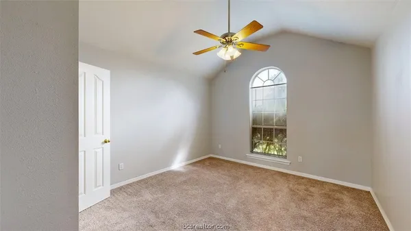 an empty room with a window and wooden floor