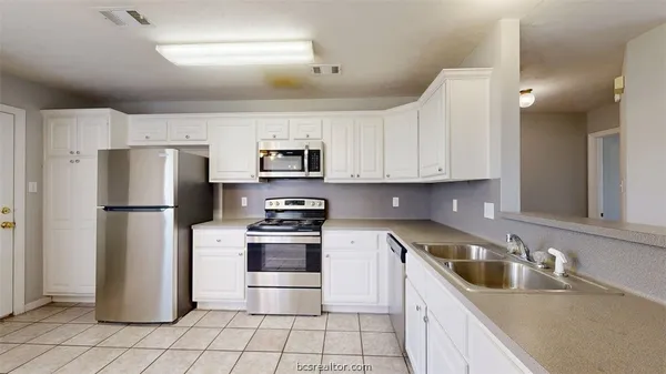a kitchen with stainless steel appliances granite countertop a refrigerator sink and stove