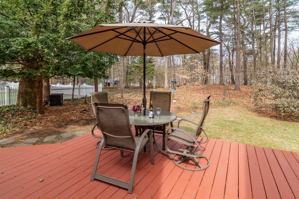 77 Parker Road Wellesley, MA 02482 - Photo 18 of 19 a view of a patio with table and chairs under an umbrella with wooden floor