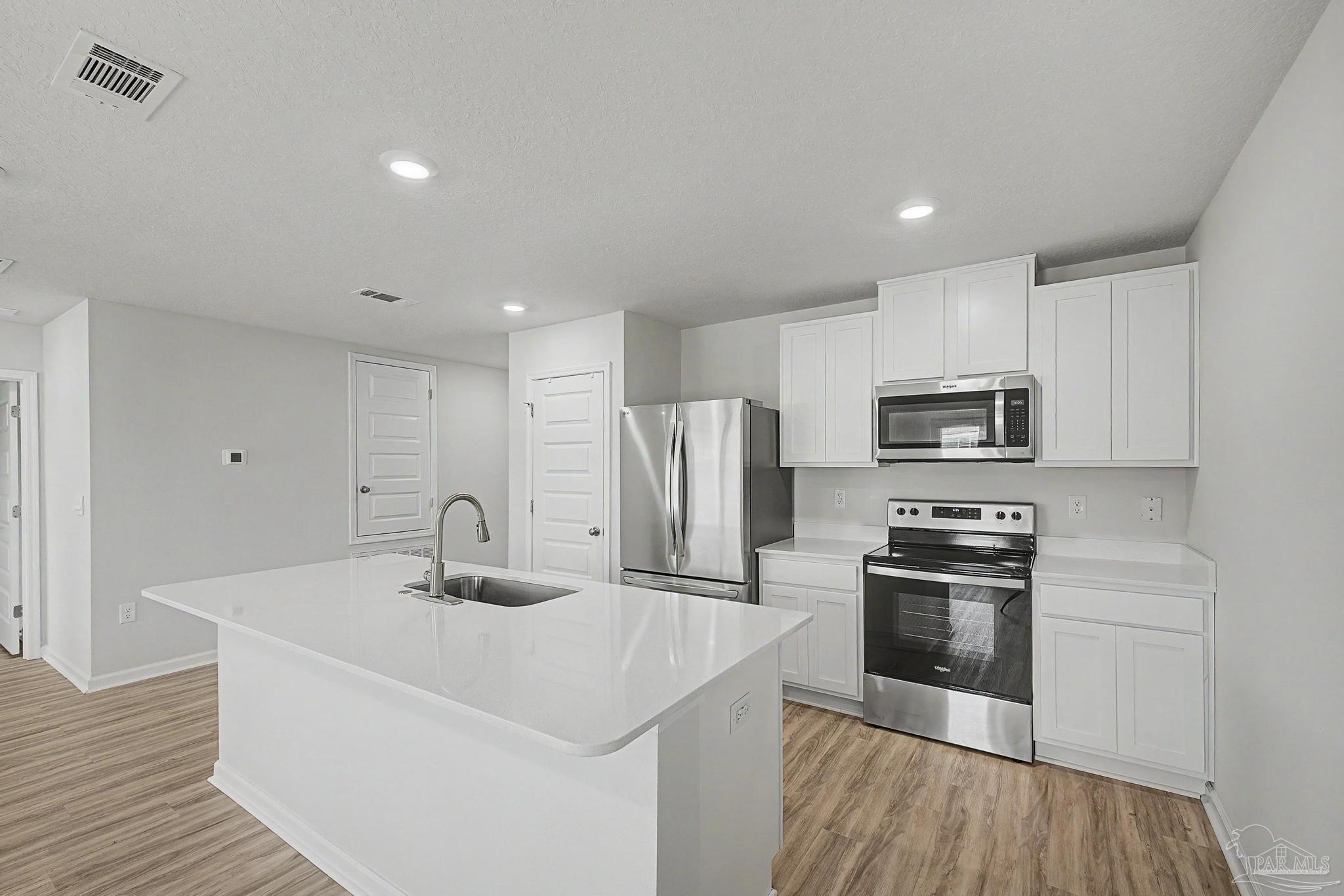 2665 Saltgrass Way Crestview, FL 32536 - Photo 20 of 22 a kitchen with stainless steel appliances a sink stove and refrigerator