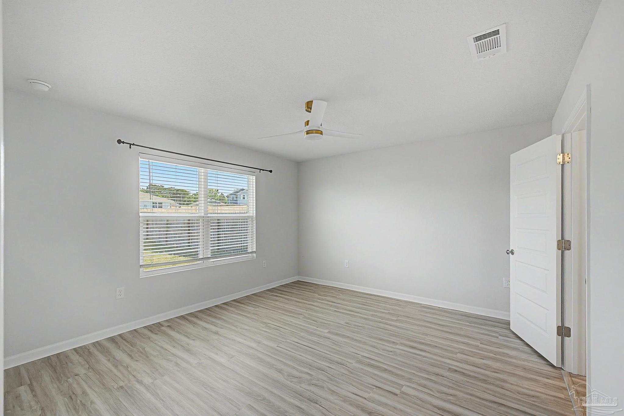 2665 Saltgrass Way Crestview, FL 32536 - Photo 21 of 22 a view of an empty room with wooden floor and a window
