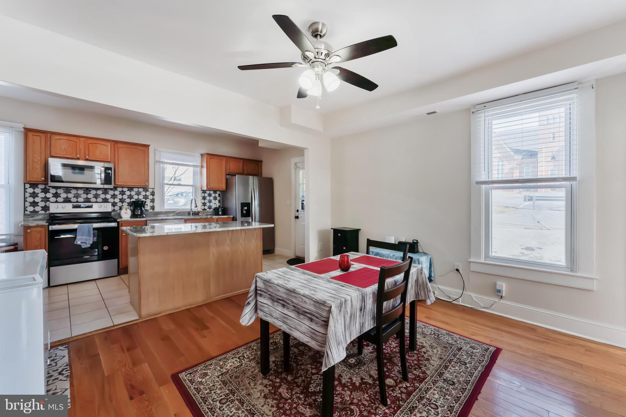 9 Carroll Street Westminster, MD 21157 - Photo 13 of 30 a kitchen with a refrigerator a stove a sink dishwasher with a dining table and chairs with wooden floor