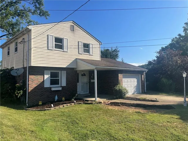 a view of house with yard outdoor seating and garage
