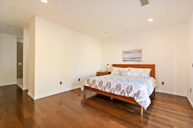 a bedroom with a bed and wooden floor