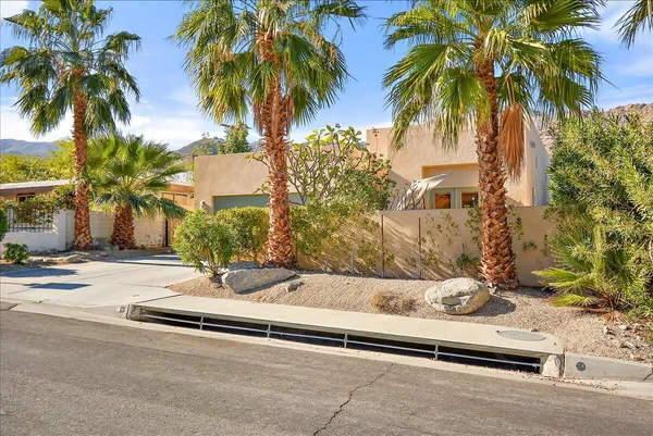 a row of palm trees in front of house