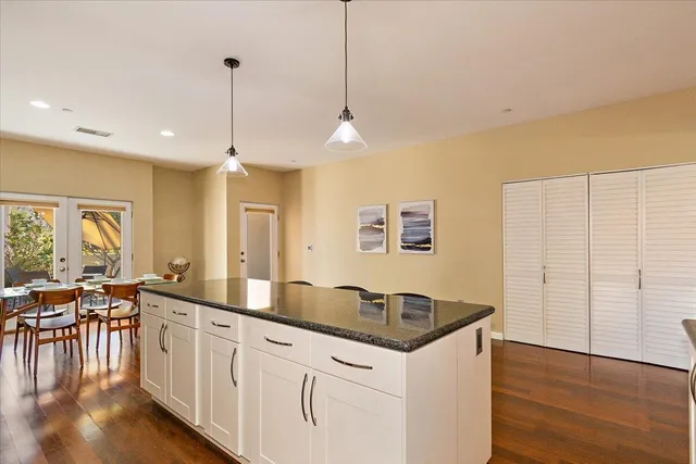 a kitchen that has a sink a table and chairs in it