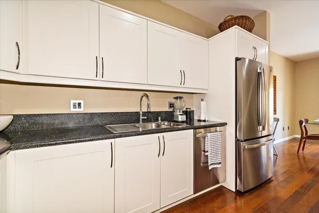 a kitchen with stainless steel appliances granite countertop a sink and a refrigerator