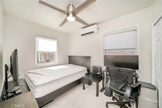 a bedroom with a bed tv and chair