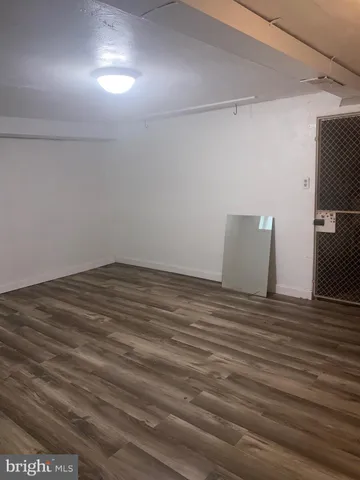 en empty room with wooden floor and windows