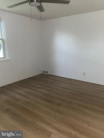 a view of a room with wooden floor and a window