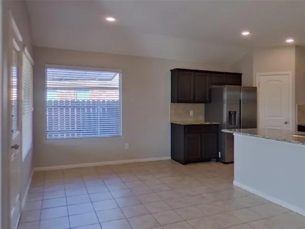 a kitchen with granite countertop a refrigerator and a stove top oven