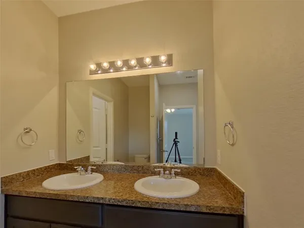 a bathroom with a granite countertop sink and a mirror