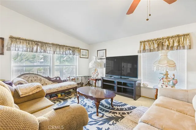 a living room with furniture a flat screen tv and a large window