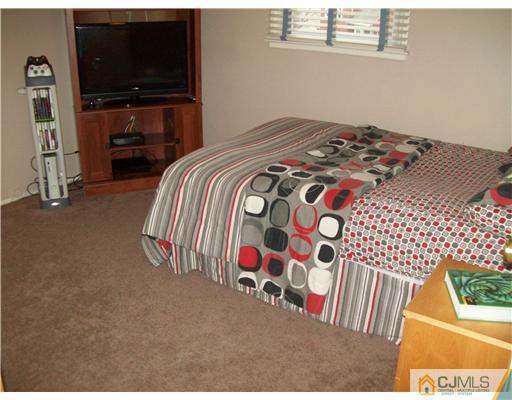 8 Phillips Road Edison, NJ 08817 - Photo 14 of 25 a bedroom with a bed and a flat tv screen