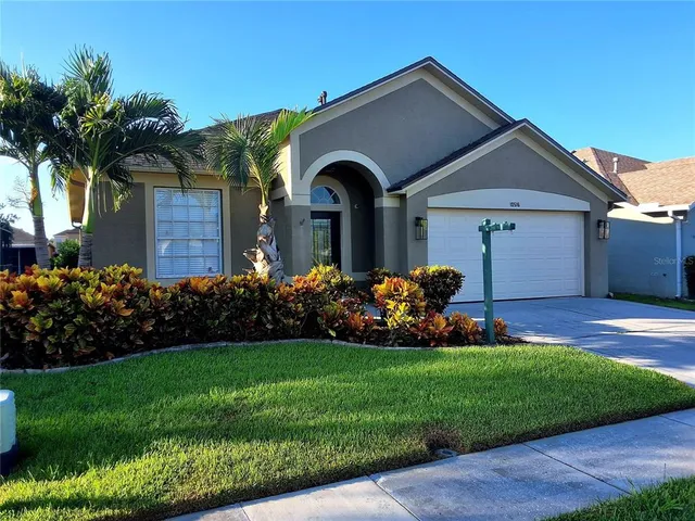 a front view of a house with a garden and plants