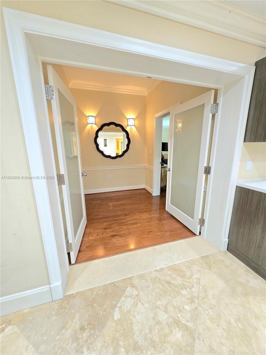 7895 Southwest 122nd Street Pinecrest, FL 33156 - Photo 17 of 78 a view of a hallway with wooden floor and white walls