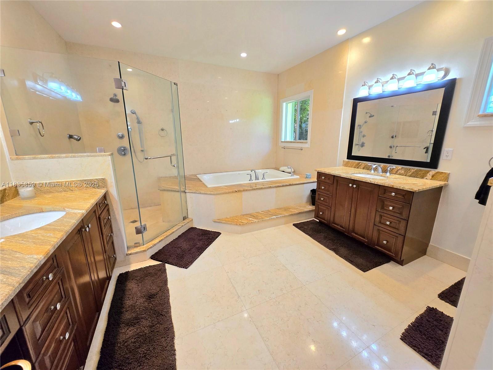 7895 Southwest 122nd Street Pinecrest, FL 33156 - Photo 22 of 78 a spacious bathroom with a tub sink a mirror a vanity and a shower