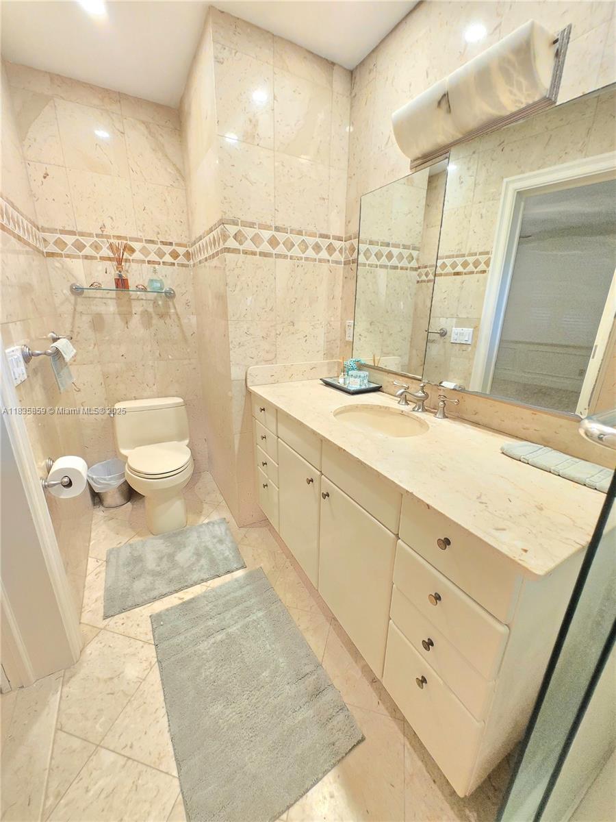 7895 Southwest 122nd Street Pinecrest, FL 33156 - Photo 41 of 78 a bathroom with a sink a toilet and a mirror