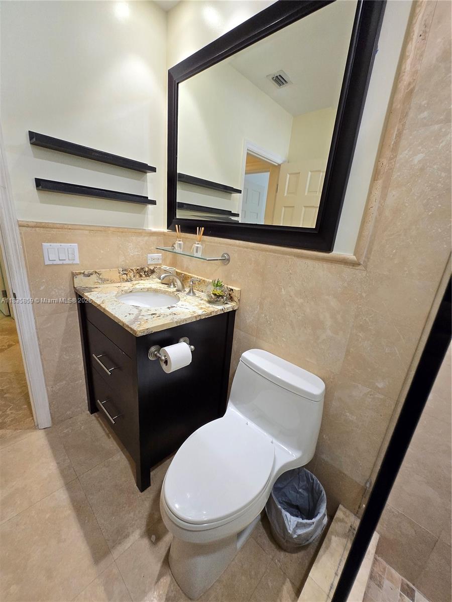 7895 Southwest 122nd Street Pinecrest, FL 33156 - Photo 49 of 78 a bathroom with a toilet sink and mirror