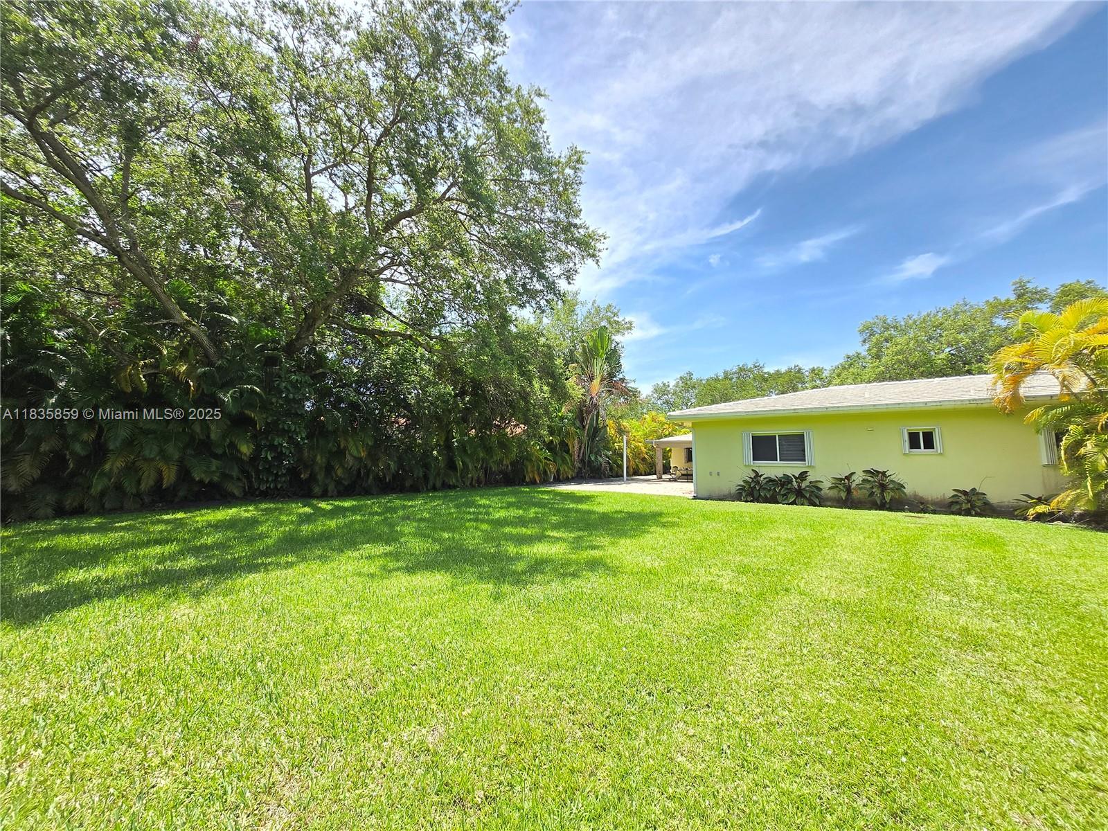7895 Southwest 122nd Street Pinecrest, FL 33156 - Photo 66 of 78 a view of a backyard with plants and a patio