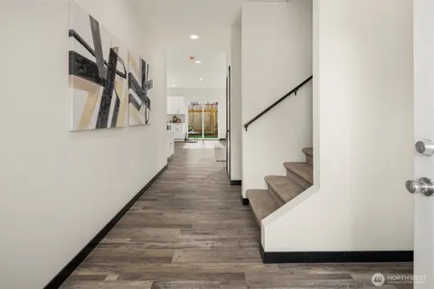 a hallway with wooden floor and stairs