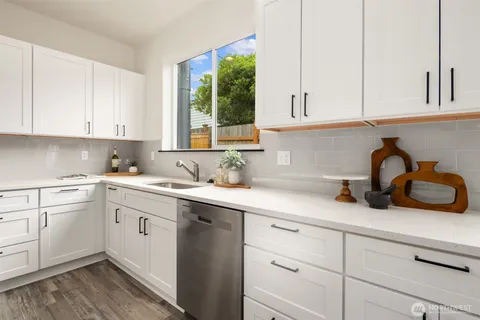 a kitchen with cabinets appliances a sink and a window