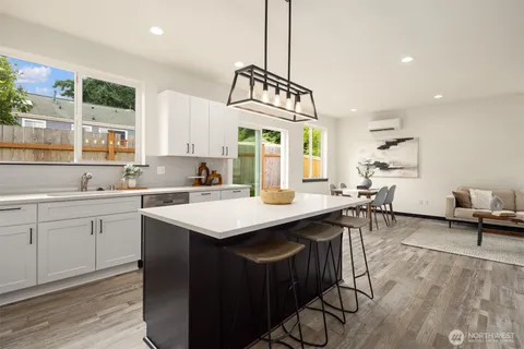 a kitchen with a sink a counter top space and living room view