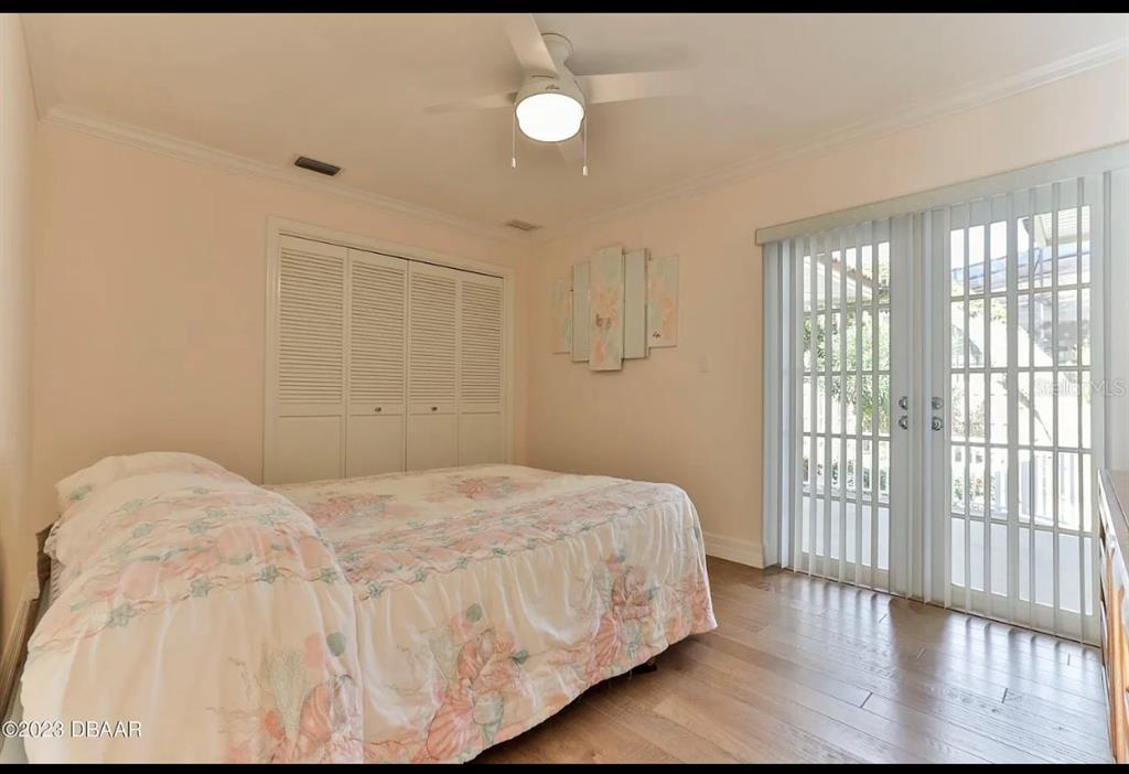 4895 Sailfish Drive Ponce Inlet, FL 32127 - Photo 11 of 34 a bedroom with a bed and wooden floor