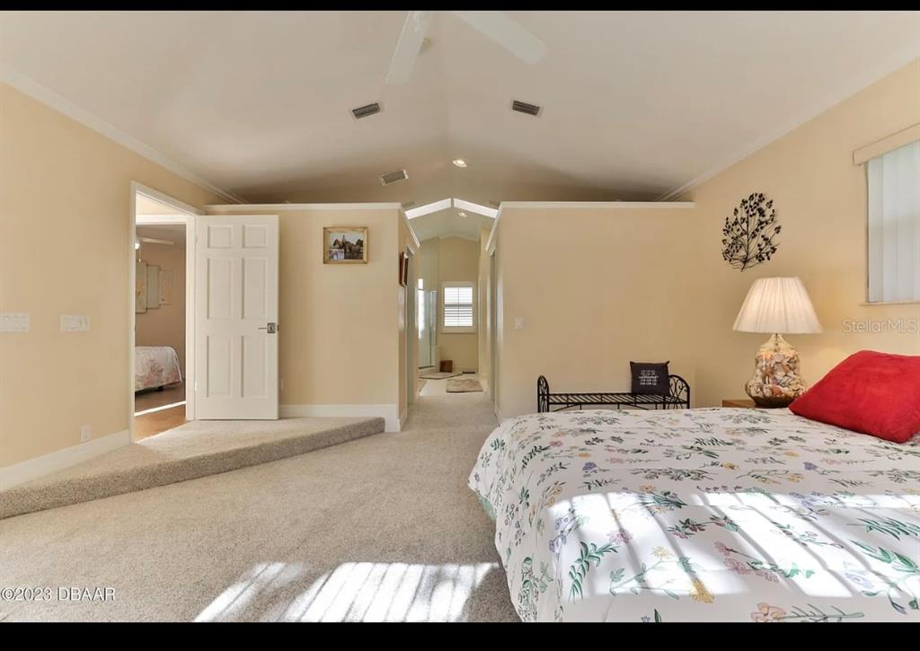 4895 Sailfish Drive Ponce Inlet, FL 32127 - Photo 14 of 34 a bedroom with a bed and a lamp