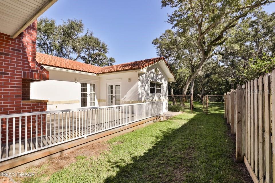 4895 Sailfish Drive Ponce Inlet, FL 32127 - Photo 24 of 34 a view of a house with backyard and trees