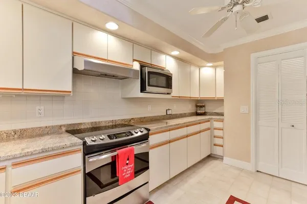a kitchen with stainless steel appliances granite countertop a stove a sink and a microwave