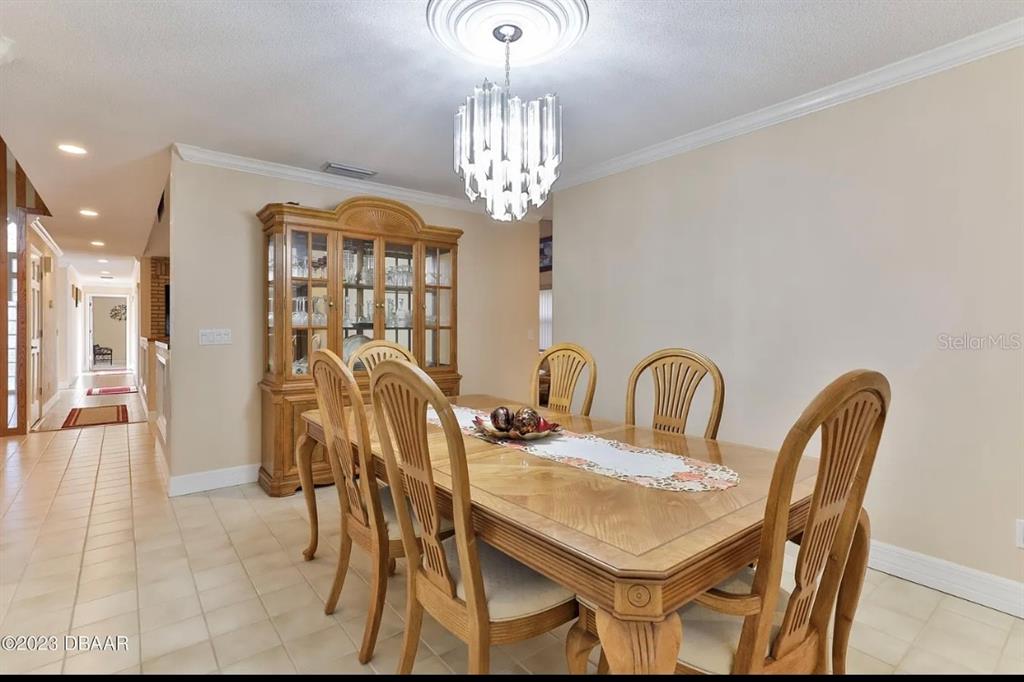 4895 Sailfish Drive Ponce Inlet, FL 32127 - Photo 5 of 34 a view of a dining room with furniture and chandelier